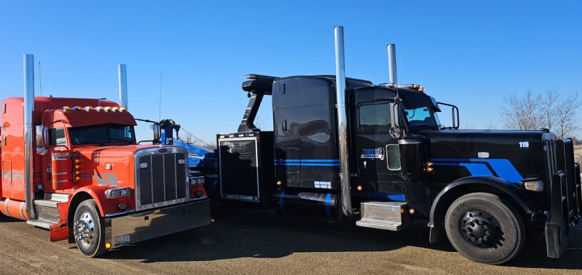 Action Towing heavy-duty black wrecker truck prepared to hook up a red semi-truck tractor, showcasing commercial towing Edmonton services.
